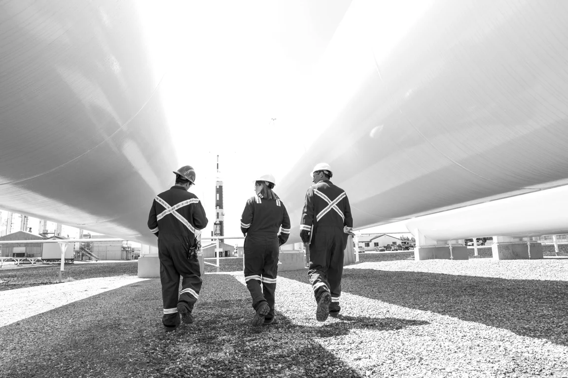 Three field-service workers walking through an industrial facility
